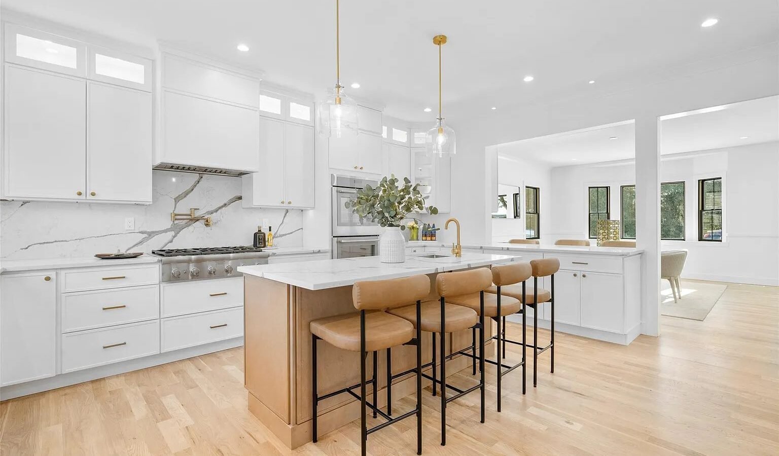 Kitchen with white cabinets and wood island with counter stools