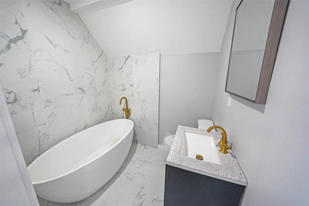 Bathroom with freestanding tub and gold faucet
