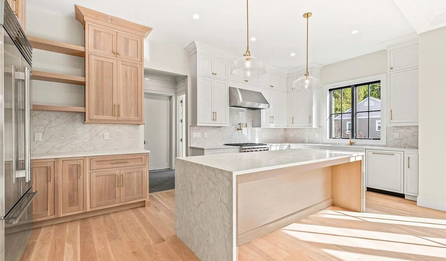 Kitchen with natural wood cabinets and stone waterfall island