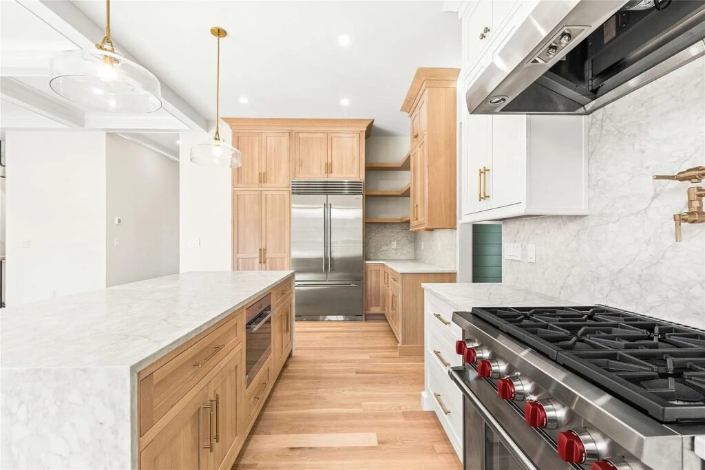 Kitchen island with wood cabinets and stainless refrigerator