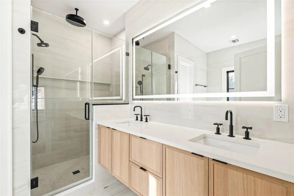 Bathroom with double wood vanity and glass shower