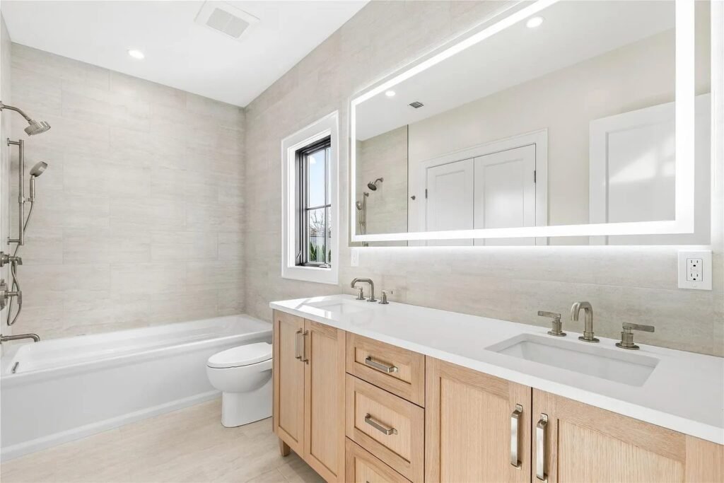 Bathroom with wood double vanity and lighted mirror