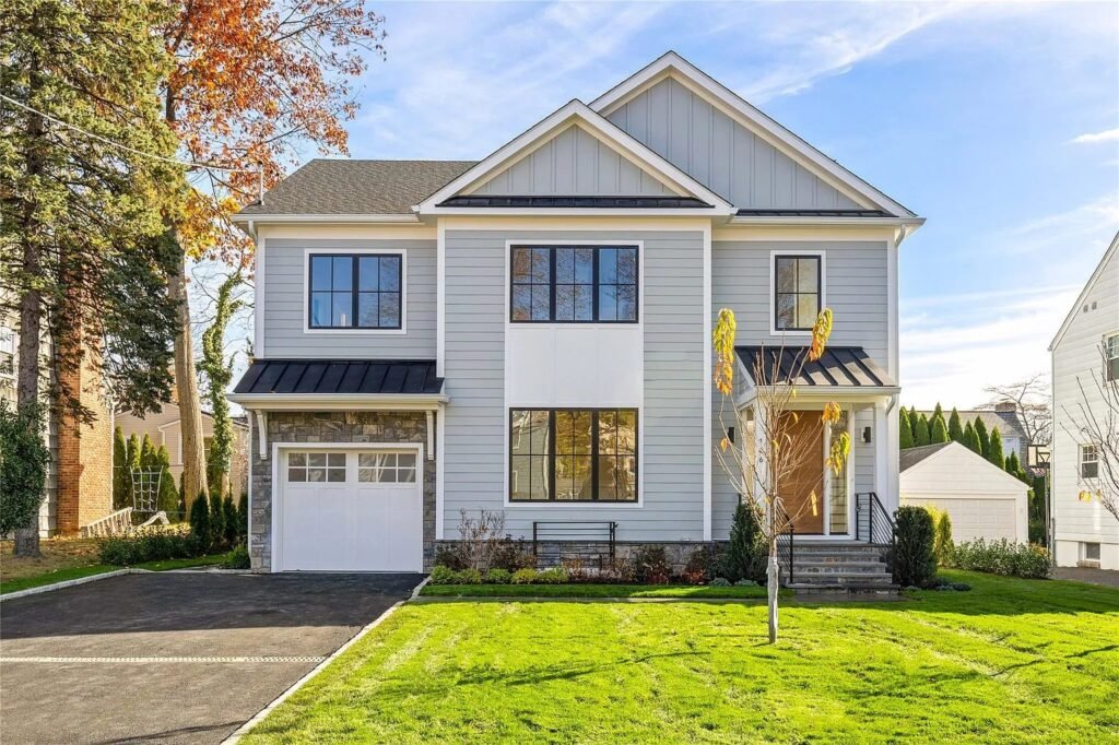 Front of a newly built gray home with green lawn