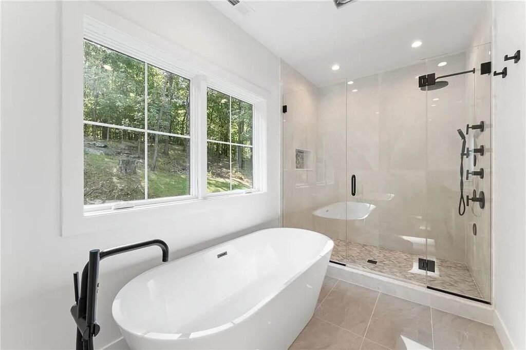 Bathroom with freestanding black tub and glass shower