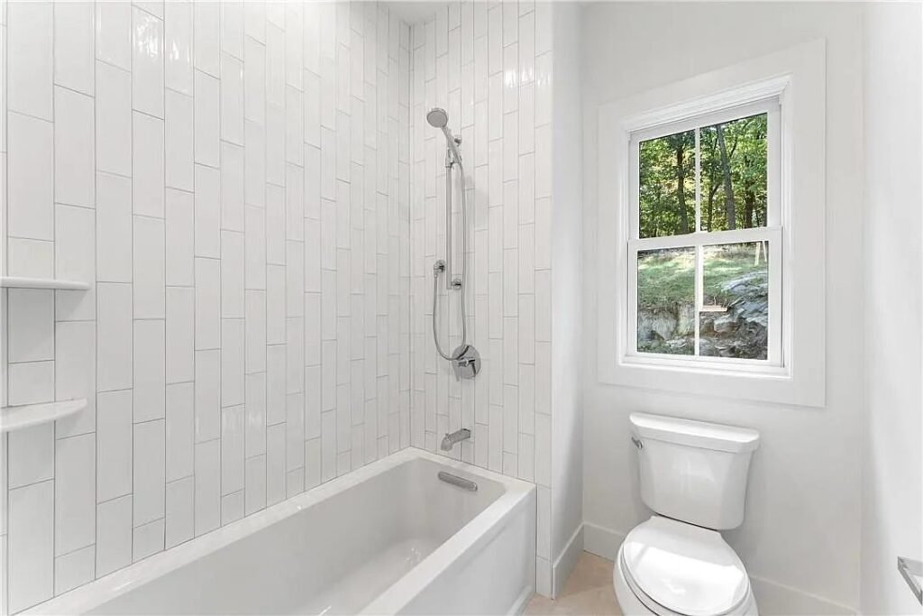 Bathroom with white vertical tile tub shower