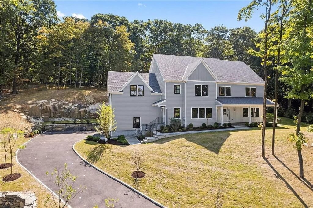 Aerial view of a gray home on a wooded lot
