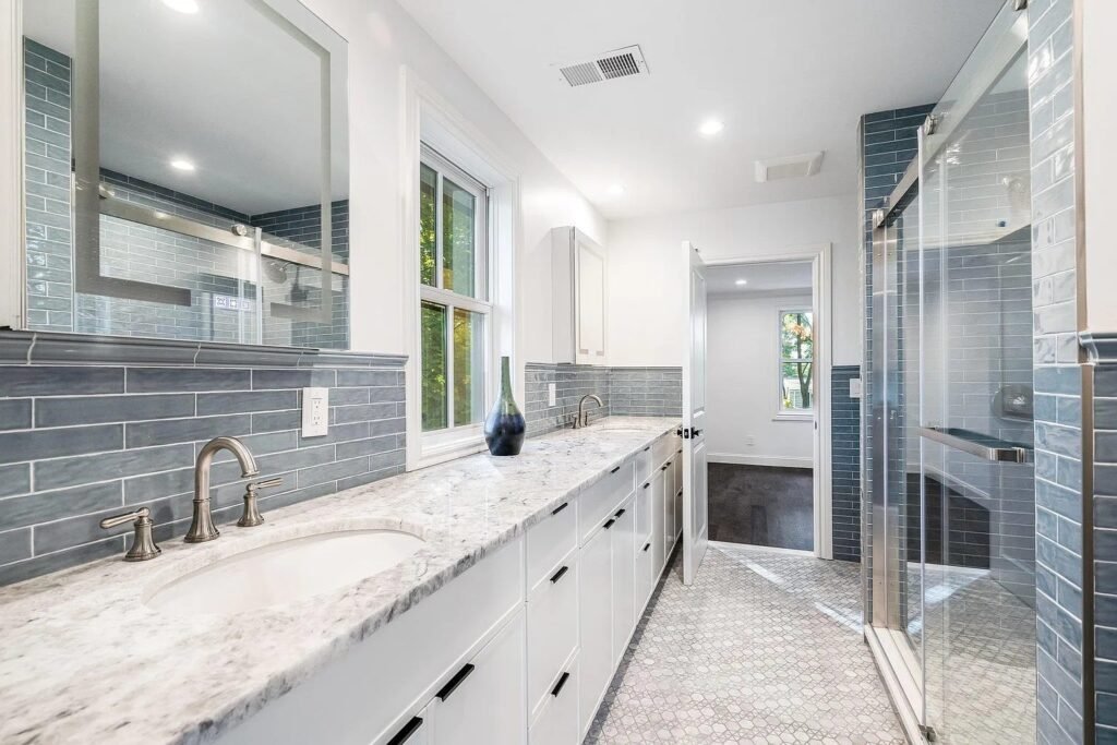 Bathroom with marble vanity top and gray tile shower
