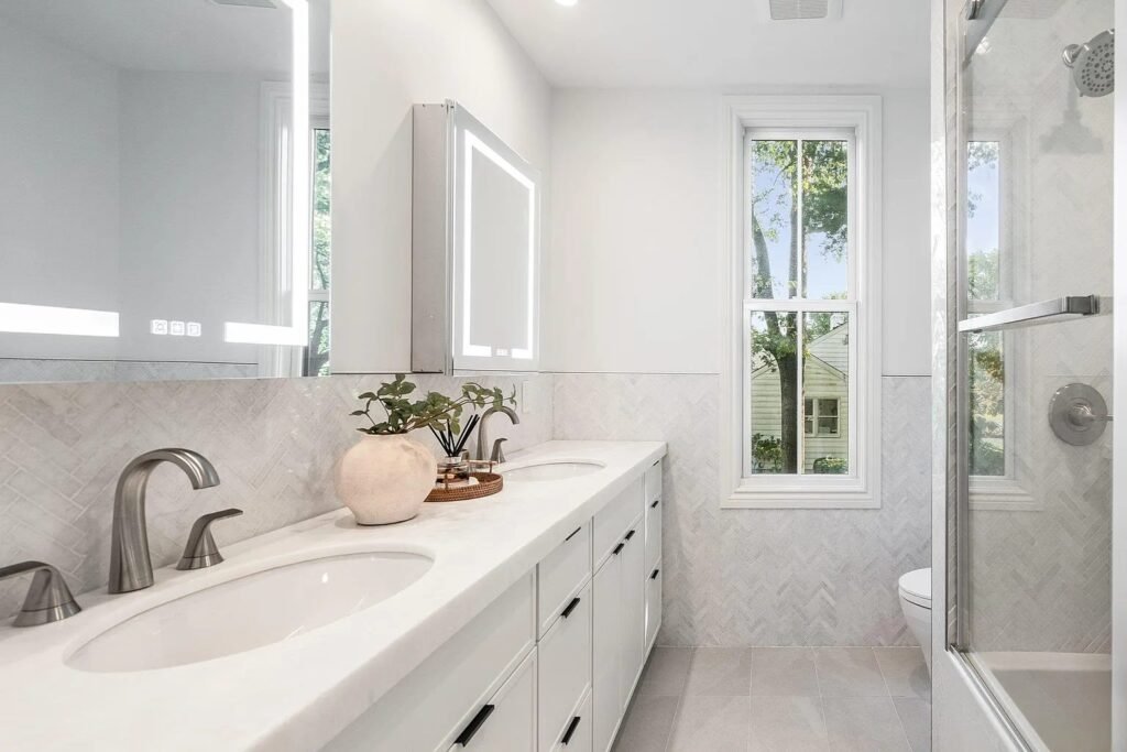 Vanity with lighted medicine cabinets and glass shower
