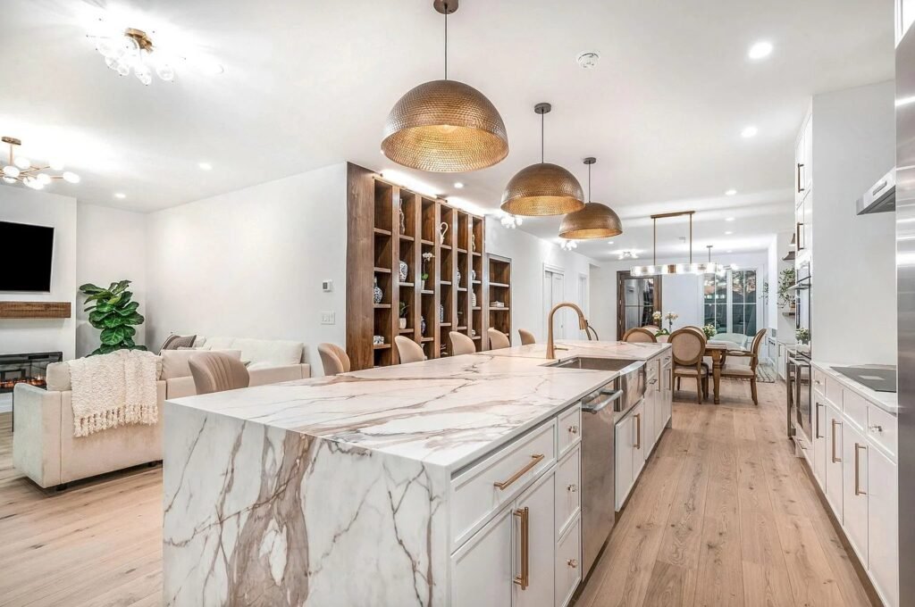 Open kitchen and dining area with marble island and wood floors