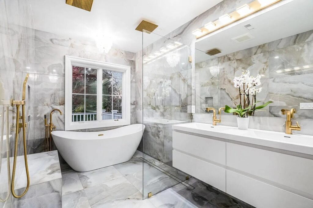 Bathroom with freestanding tub, marble tile and gold fixtures
