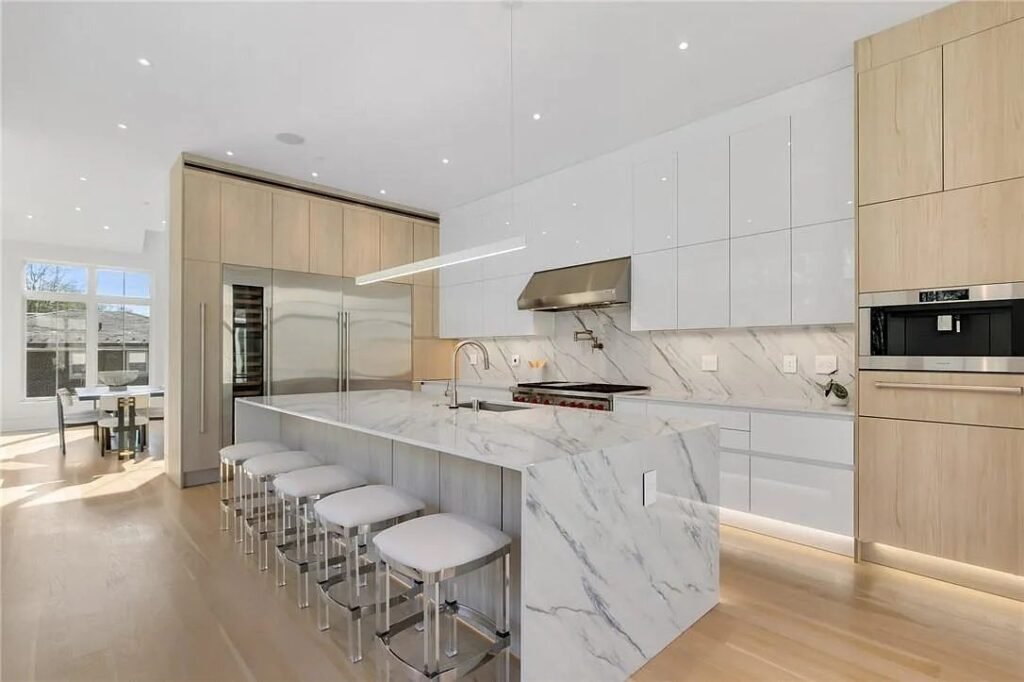 Kitchen with white and light wood cabinets and marble backsplash