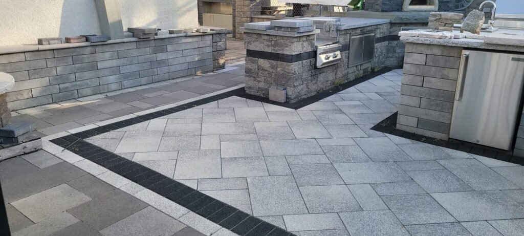 Outdoor kitchen with built-in grill on a paver patio