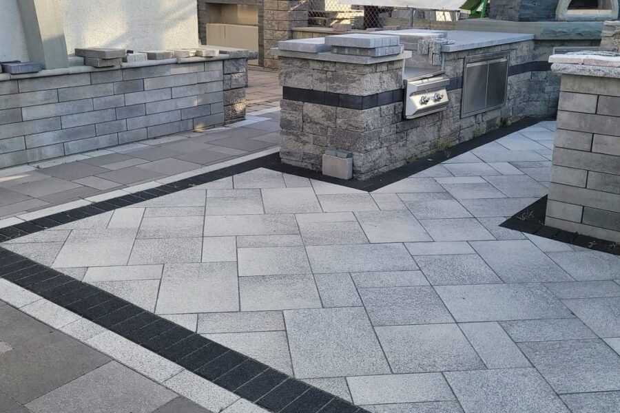 Outdoor kitchen with built-in grill on a paver patio