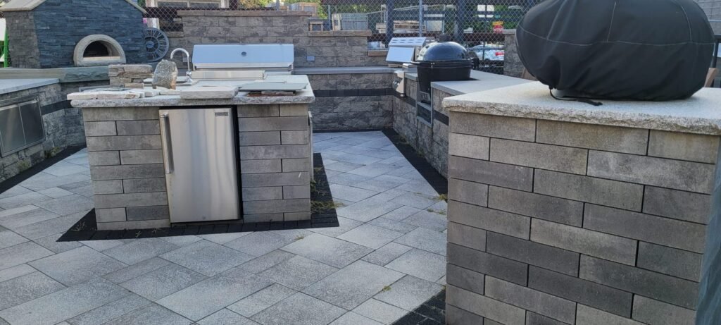 Stone outdoor kitchen with grill and refrigerator