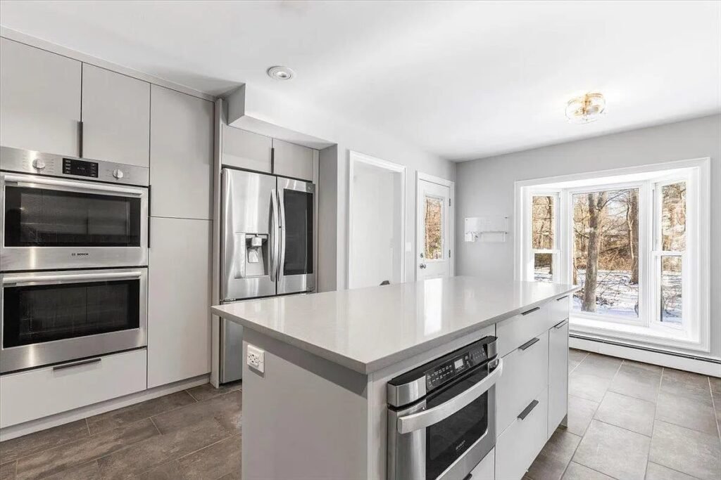 Kitchen with double ovens and white island
