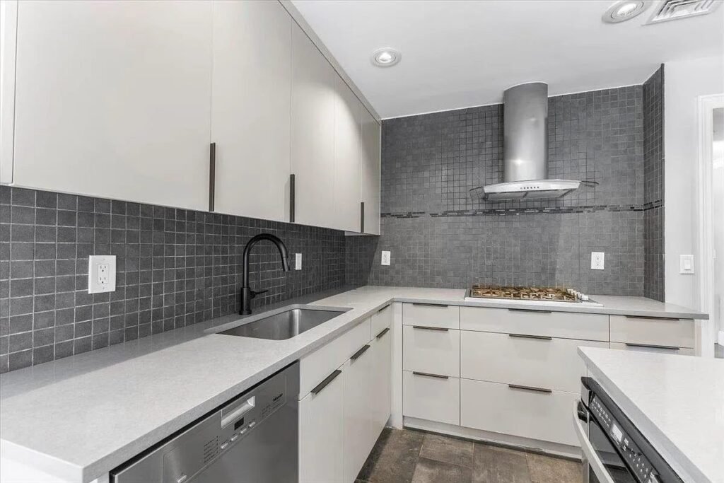 Kitchen with gray tile backsplash and white cabinets