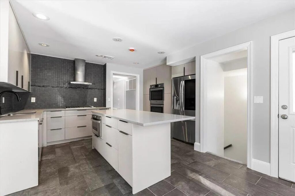 Kitchen with island and dark tile backsplash