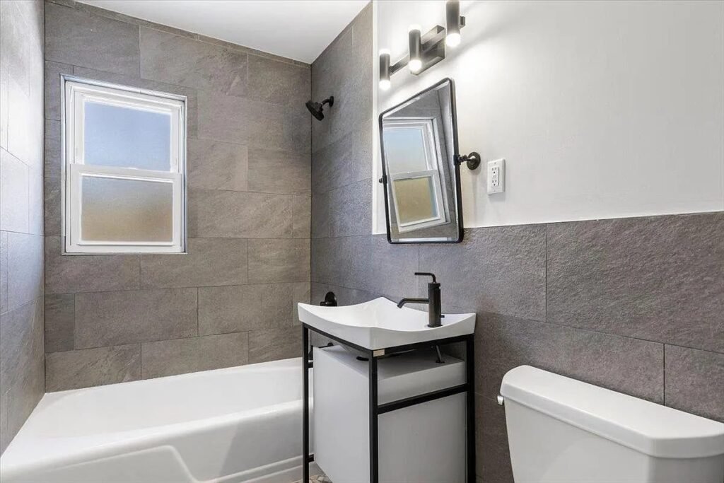 Bathroom with dark tile wall and tub