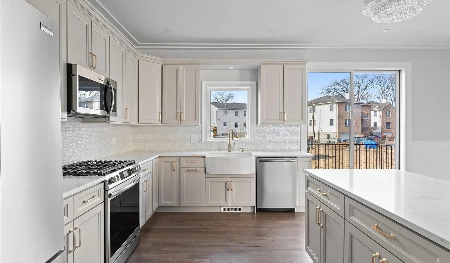 Kitchen with light cabinets, gas range and white counters