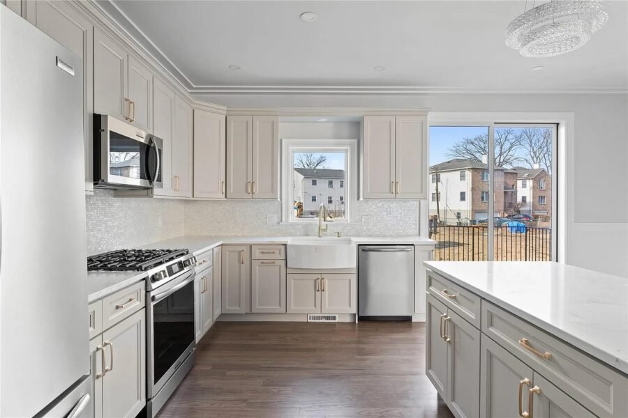 Kitchen with light cabinets, gas range and white counters