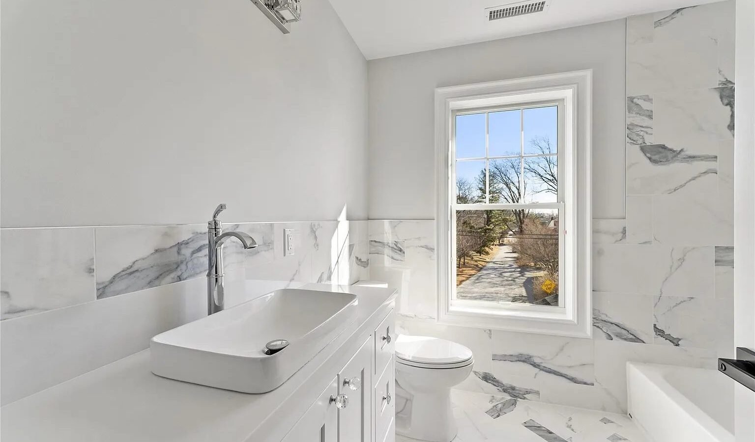 Bathroom with vessel sink and marble tile