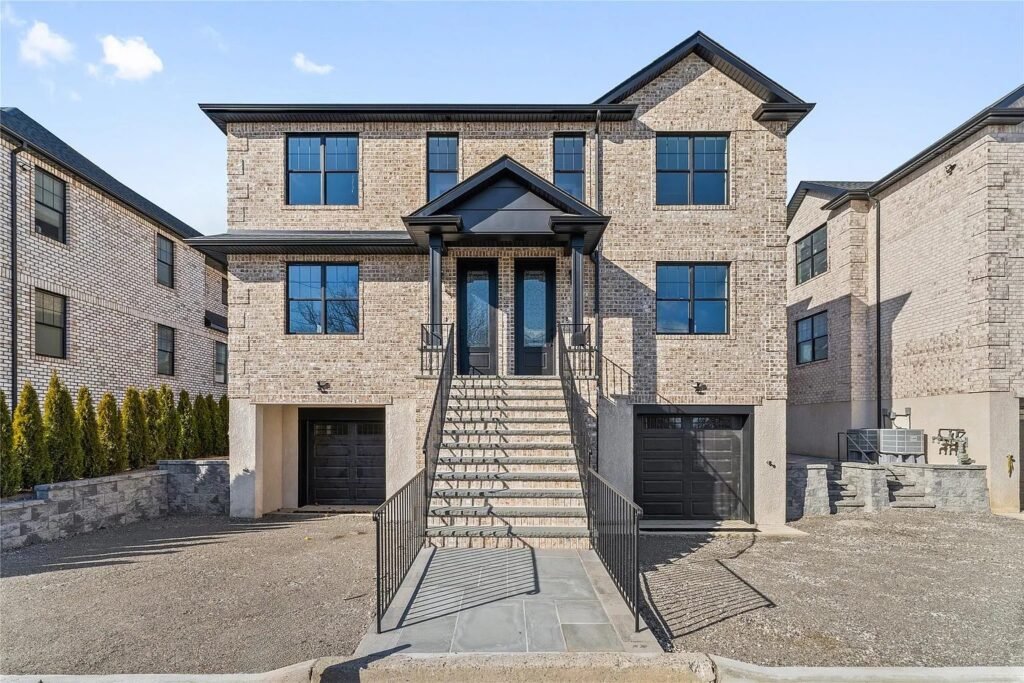 Front of a brick three-story home with garage